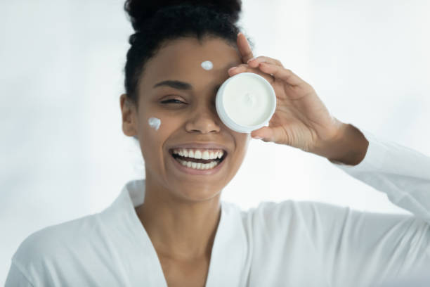 istock Happy attractive multiracial lady using moisturizing nourishing balm. 1399779901