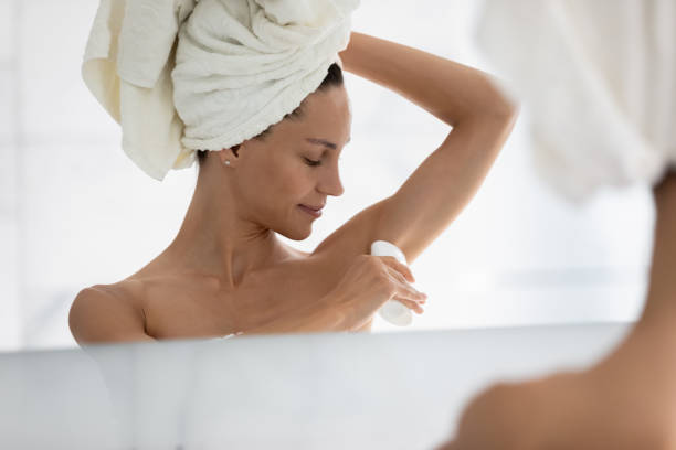 istock Smiling attractive latin hispanic woman applying deodorant. 1399780044