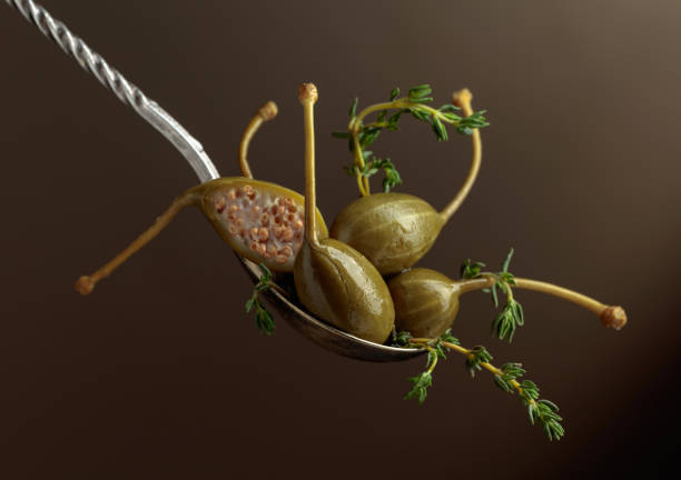 istock Large pickled capers with thyme on a brown background. 1399781317