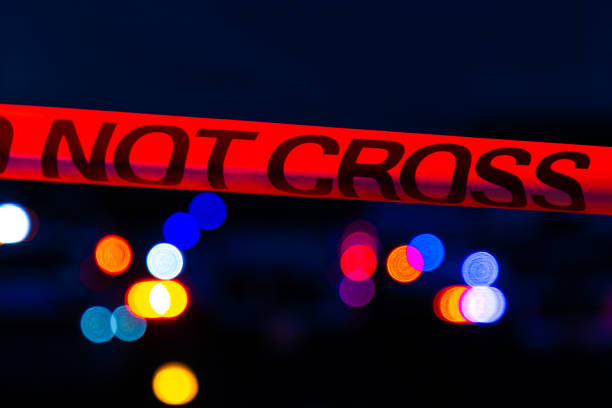 焦点の合っていない警察のライトの前にある犯罪現場のテープ - forensic science flash ストックフォトと画像