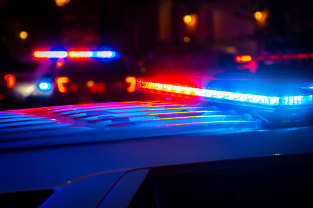 rote und blaue polizeilichter in der stadt - polizeiauto stock-fotos und bilder