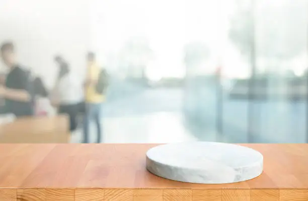 Wood table top on blur window glass,wall in shop retail  background