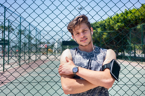 Portrait of young sportive man on a running track.