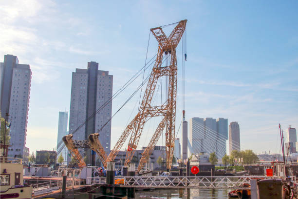 vieille grue dans le port nommée leuvehaven à downtwon rotterdam par une journée ensoleillée - named logistics company photos et images de collection