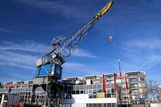 vieille grue dans le port nommée leuvehaven à downtwon rotterdam par une journée ensoleillée - named logistics company photos et images de collection