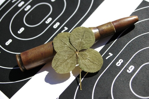 A four-leaf clover and a 30 30 round on a target sheet backdrop