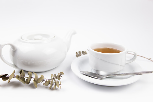 white tea set with teapot tea and saucers and pie for breakfast