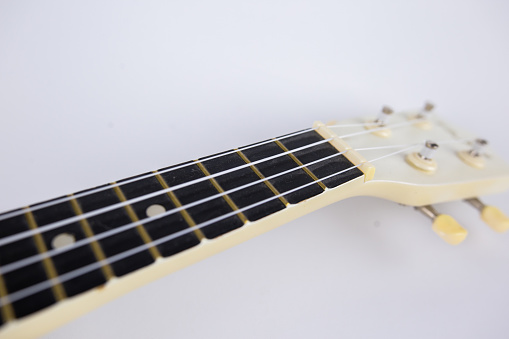 a strings of a beautiful white guitar close-up on a white background ukulele