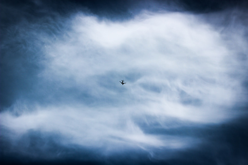 Airplane flying over in a moody sky