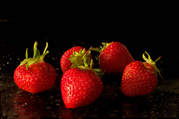 istock strawberry fruits lie on a black background 1399789996