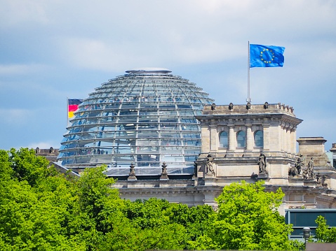 The German parlement building with the German and European flag on top.