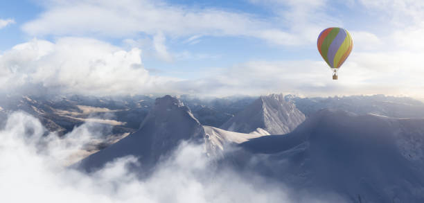 istock Dramatic Mountain Landscape covered in clouds and Hot Air Balloon Flying 1399797331