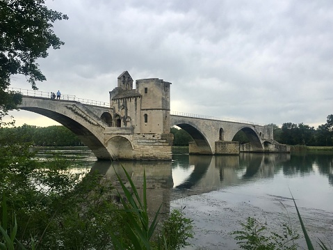 View of Pont d’Avignon (famous medieval bridge) from Boulevard de la Ligne. Historic remains of 12th century bridge over Rhone river in Provence. Selective focus