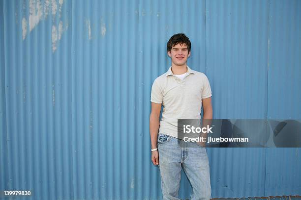 Lächelnder Junger Mann Vor Blauer Wand Stockfoto und mehr Bilder von Jungen - Jungen, Polohemd, Abgeschiedenheit