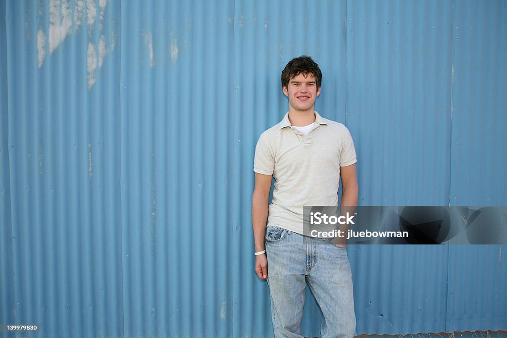 Souriant jeune homme contre mur bleu - Photo de Petits garçons libre de droits