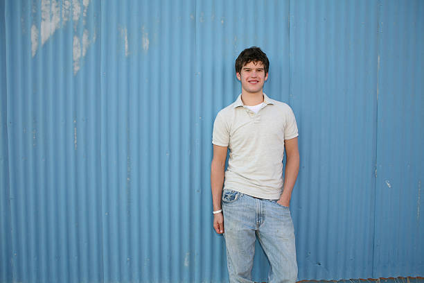 Smiling young man against blue wall