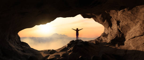 istock Dramatic Adventurous Scene with Woman standing inside a Rocky Cave 1399799921