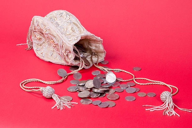 coins spilling from a purse stock photo