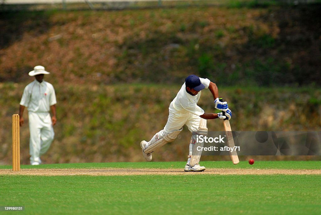 Cricket batsman swinging at a pitch A cricket batsman getting ready to hit Sport of Cricket Stock Photo