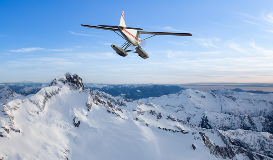 Seaplane flying over the Rocky Mountains. 3d Rendering Airplane Adventure Artwork. Aerial Image from British Columbia, Canada.