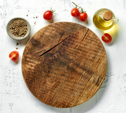 empty round wooden cutting board on white table, top view