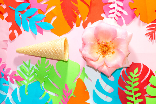 ice cream cone with pink flower head on jungle colorful background, creative summer design