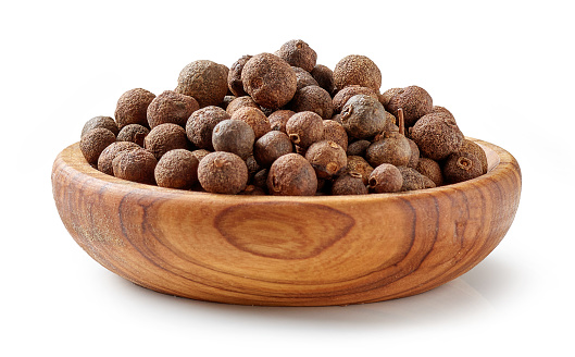 aromatic black pepper in olive wood bowl isolated on white background