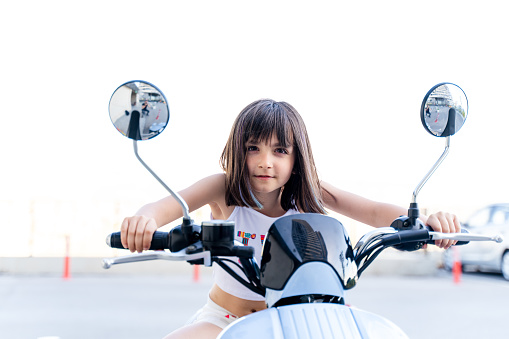 A portrait of a girl  on motorbike  looking at the camera