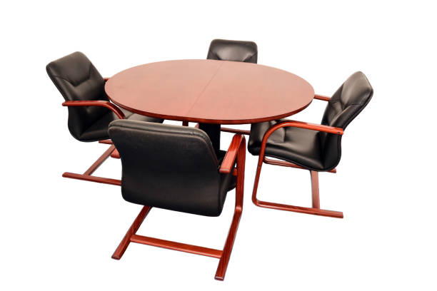 istock Four empty leather office chairs sit around a round table. On a white clipping background 1399806234