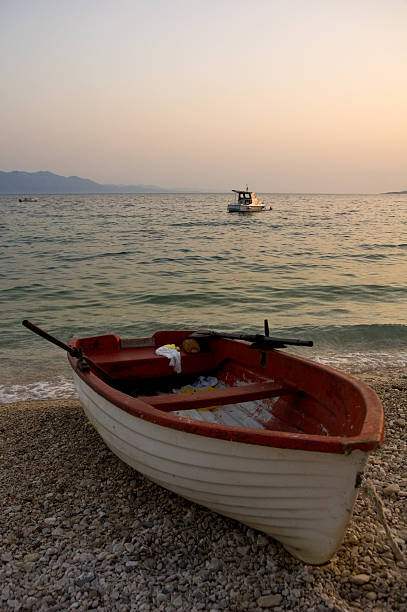 fishing boat on beach at sunset stock photo