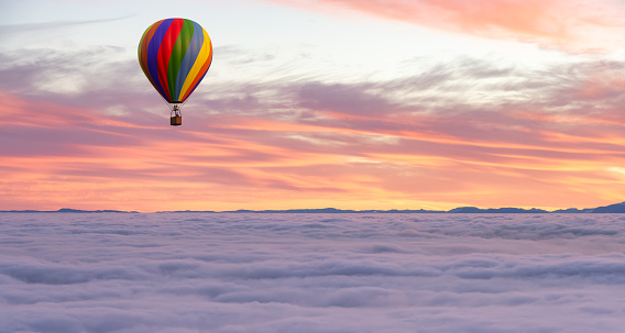 Hot Air Balloon flying over Canadian Nature Landscape on the Pacific West Coast over the clouds. foggy Winter Day. 3d Rendering aircraft Adventure Concept. West Vancouver, British Columbia, Canada.