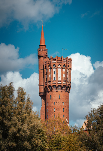 Landskrona, Sweden - May 26, 2022: Historical water tower designed by architect Fredrik Sundbärg and built 1904. The water tower is 66 meter high. Converted into apartments in 1992. Selective focus.