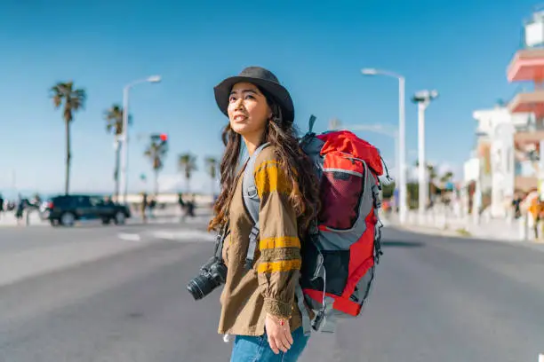 Photo of Young female traveller walking in city and enjoying her vacation