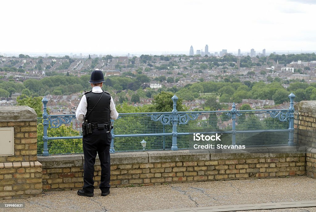 Policing London A lone policeman looks out over London, from the north towards the City which can be seen on the horizon. Police Force Stock Photo