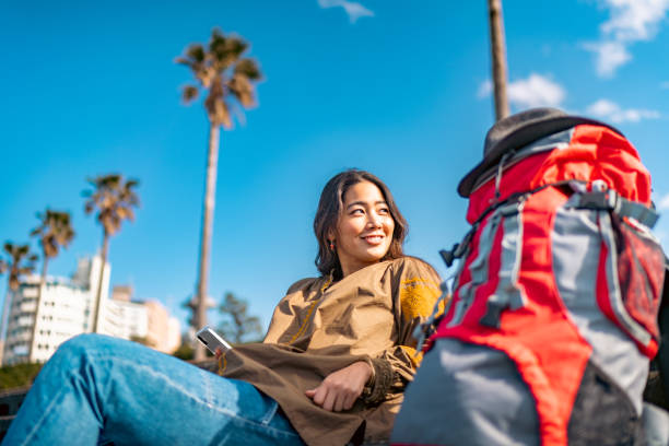 Young female traveller using smart phone while enjoying her vacation