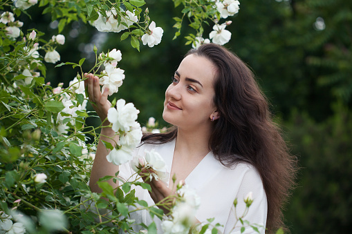 Happy young woman in a beautiful garden