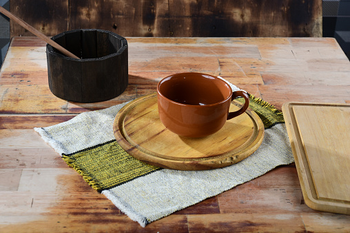 large empty cup for broth, soup and coffee, on the wooden table