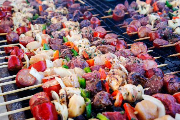 Woman in the garden preparing barbecue with vegetarian skewers.
