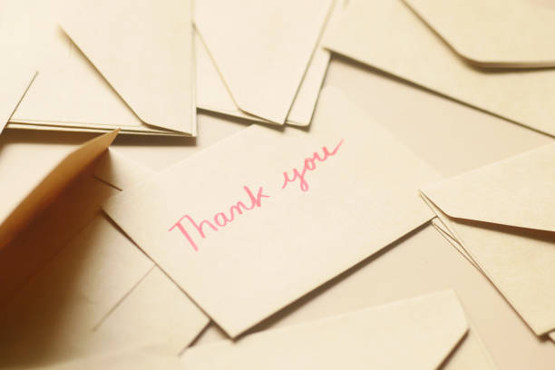 thank you message and envelope on wooden table.