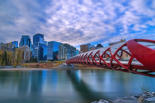 A cloudy blue sky over the Peace Bridge, which was designed by Spanish architect Santiago Calatrava and opened for pedestrian use in 2012, that crosses over the Bow river by downtown Calgary.