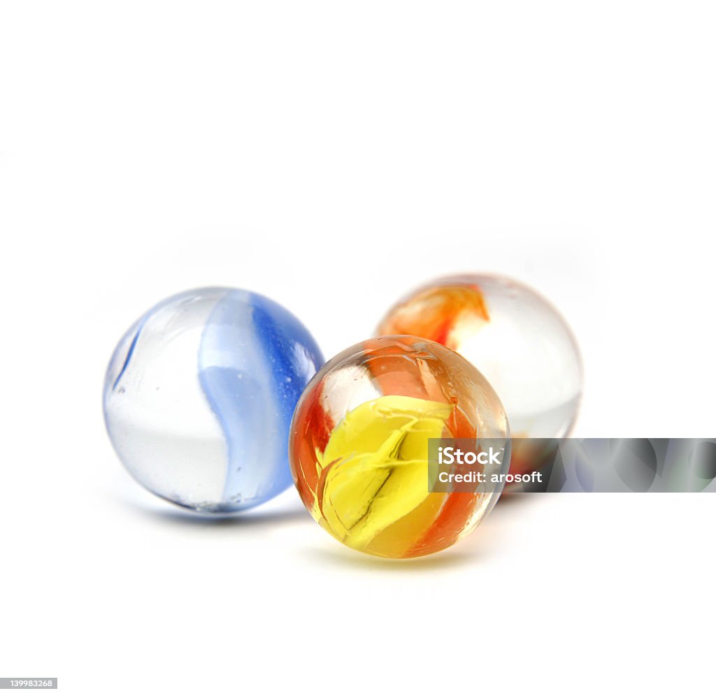 Three Orange Blue And Yellow Glass Marbles On White Surface Stock Photo -  Download Image Now - iStock