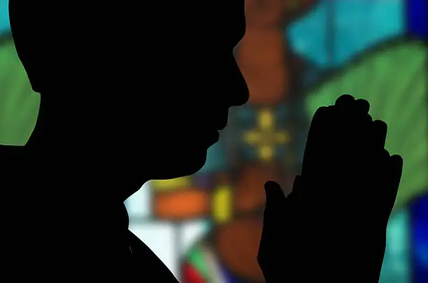 Photo of Blacked out silhouette of someone praying