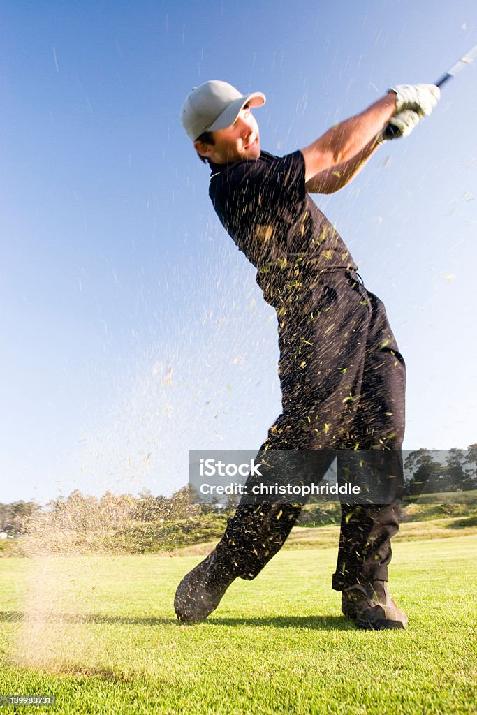 The Shot A young golfer hits the ball sending grass flying into the air (motion blur) Golf Club Stock Photo