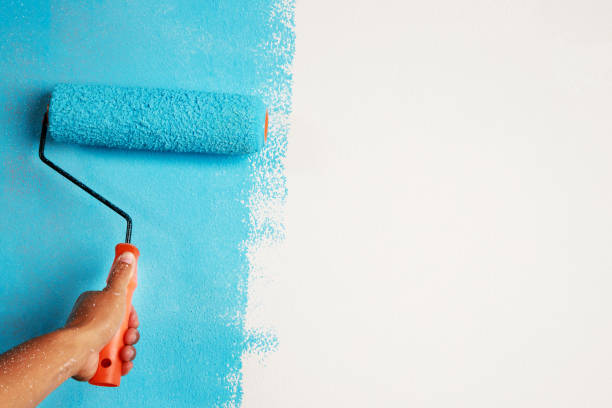 roller brush painting, worker malowanie na ścianie powierzchniowej malowanie mieszkania, renowacja niebieską farbą. pozostaw puste miejsce na kopiowaniu na biało, aby napisać tekst opisowy obok. - paint brushing house painter wall zdjęcia i obrazy z banku zdjęć