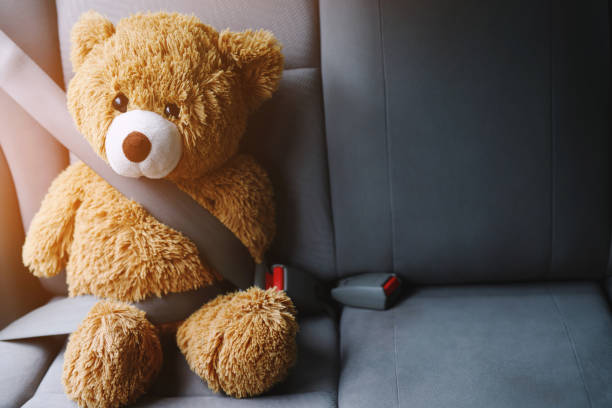 istock Brown teddy bear wearing car seat belt 1399844694