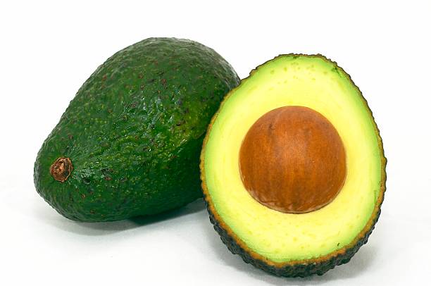 Green whole with cut avocado stock photo