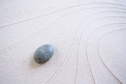 Zen Garden Japanese pattern on white sand background. buddhism texture wave on desert nature at coast of shore. top view line abstract on beach with stone. Purity Meditation calm or lifestyles spa.
