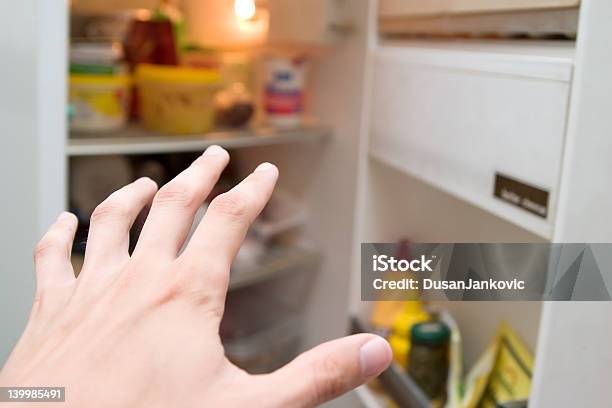 Hand Reaching Toward The Refrigerator In Hunger Stock Photo - Download Image Now - Over Eating, Refrigerator, Cold Temperature