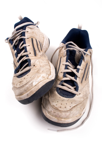 Old dirty tennis shoes on white background