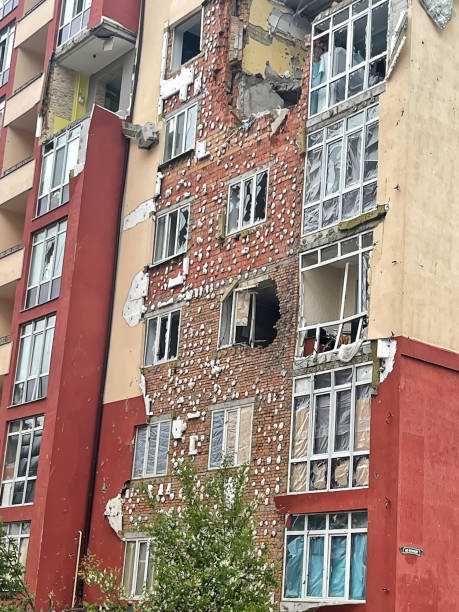 irpen, ukraine. may 07. 2022. fragment of the facade of a residential building with walls destroyed by the shelling of the occupiers, broken windows - distress rocket imagens e fotografias de stock